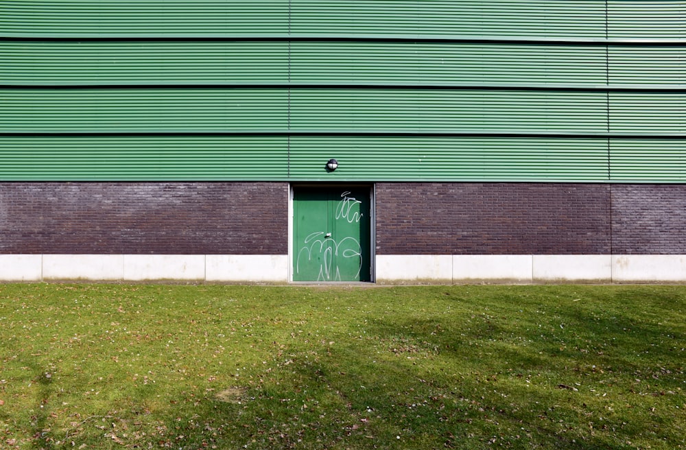 Una puerta verde frente a un edificio verde