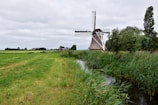 a windmill in a field next to a river