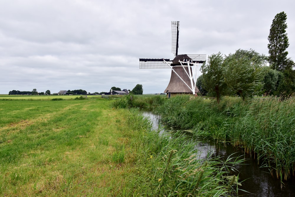 a windmill in a field next to a river