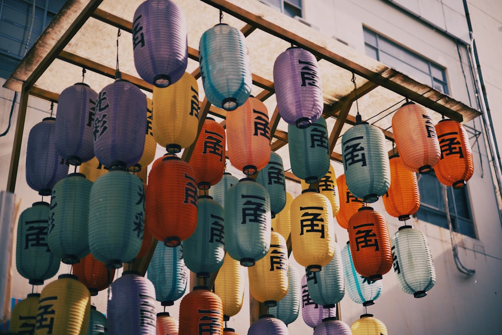 a bunch of paper lanterns hanging from a building