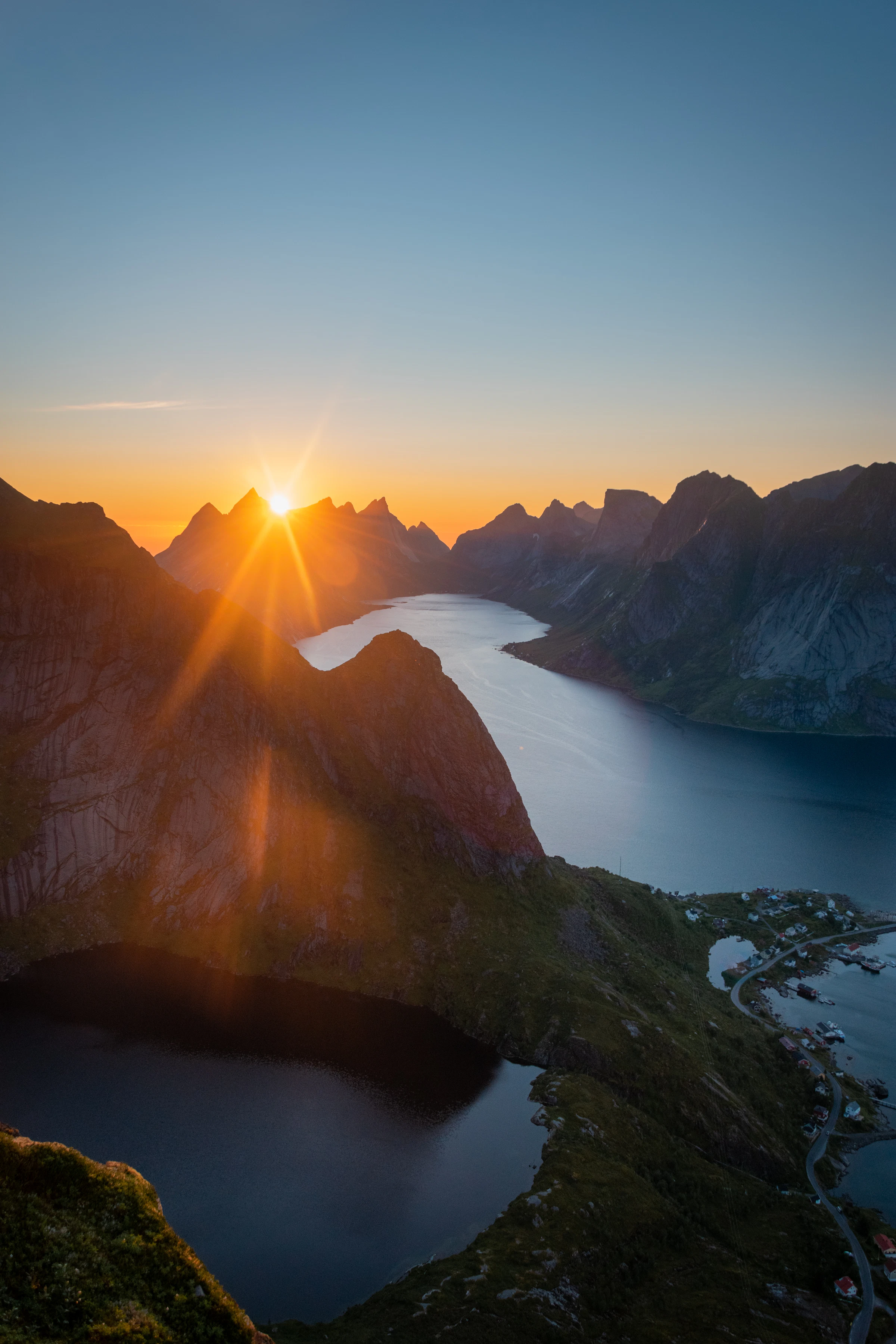 The midnight sun glowing low over the Lofoten fjord and peaks in summer