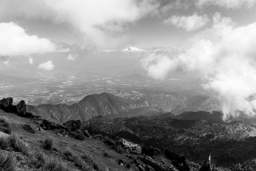 a black and white photo of mountains and clouds