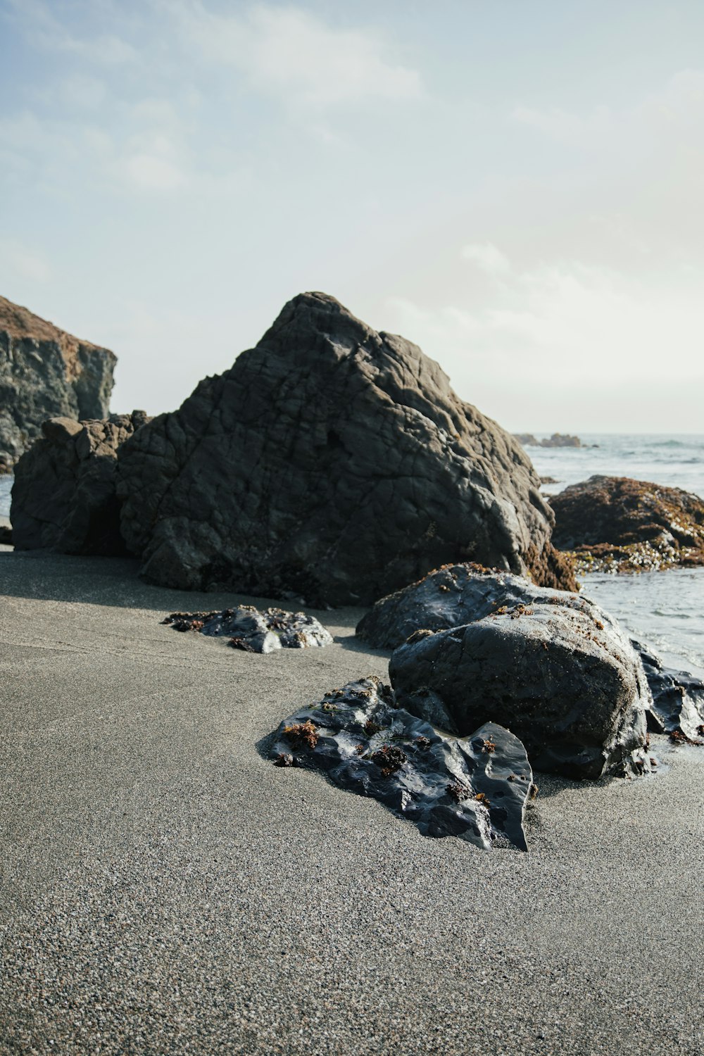 a rock formation on a beach next to the ocean