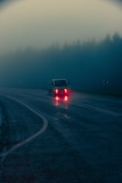 Night view of a MG Log Transportes truck illuminated by streetlights on the road.