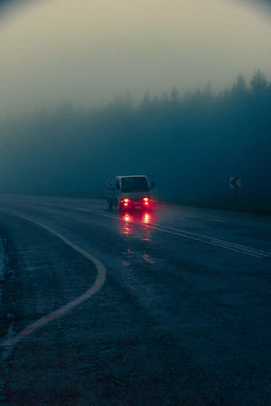 Night shot of a SwiftTrack truck illuminated by red taillights on a dark interstate