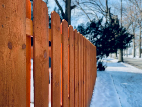a close up of a wooden fence in the snow