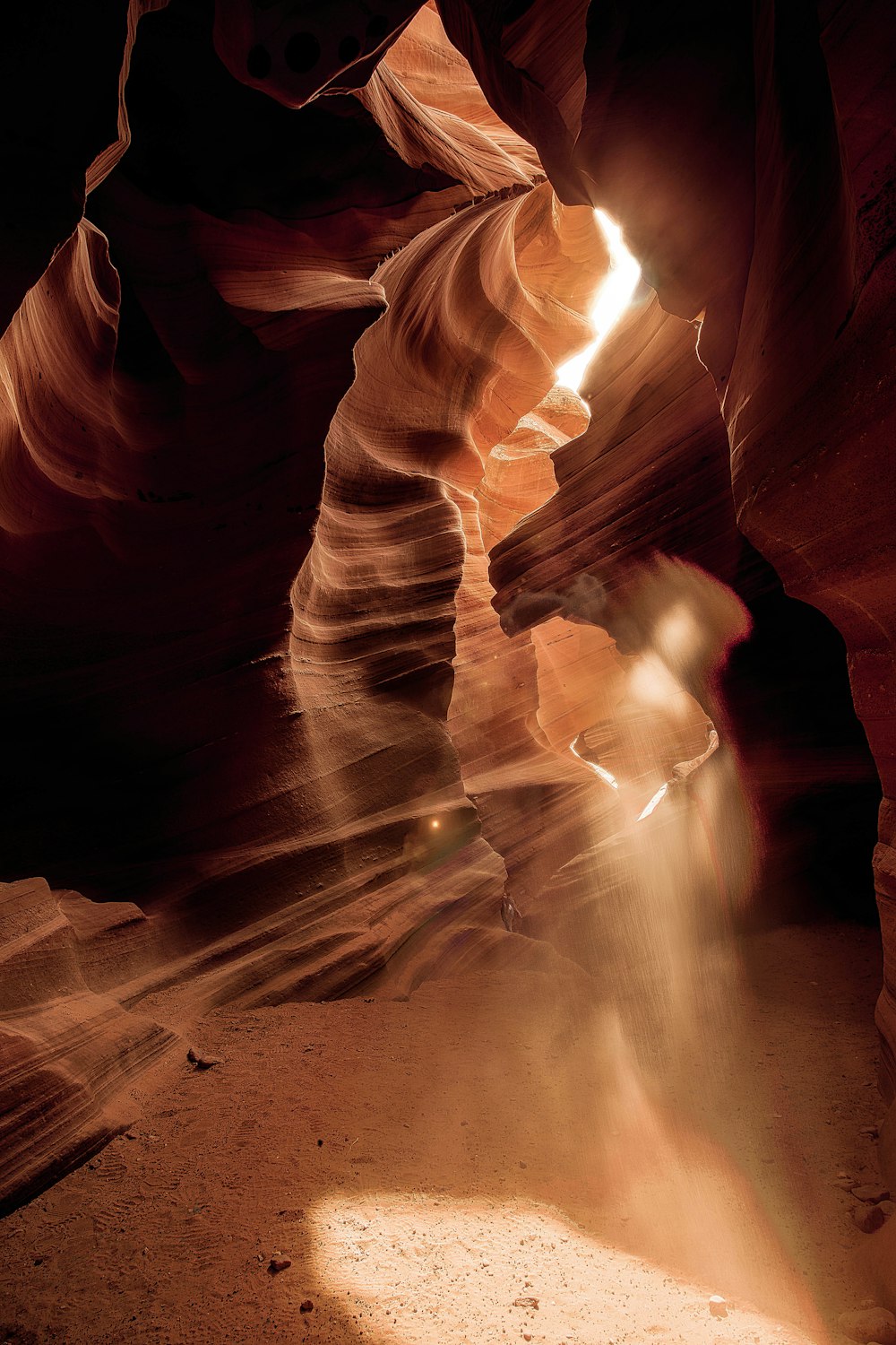 Une lumière brille à travers une fente étroite dans un canyon