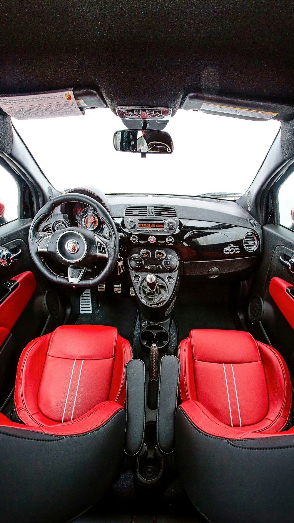the interior of a car with red and black seats
