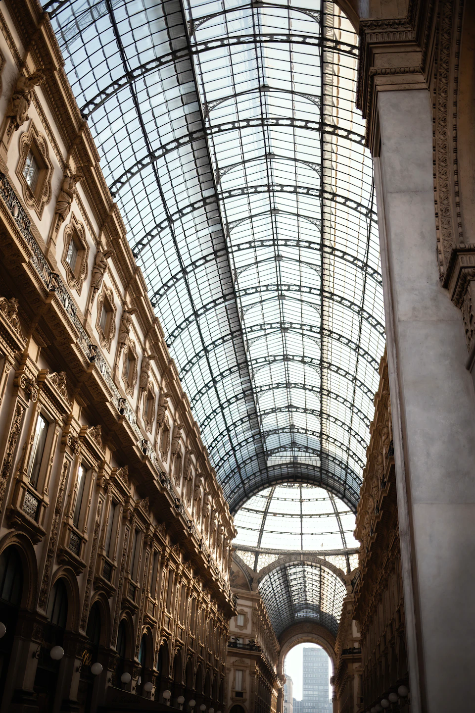 Long grand hallway with high ceiling and large glass windows above ornate architectural details