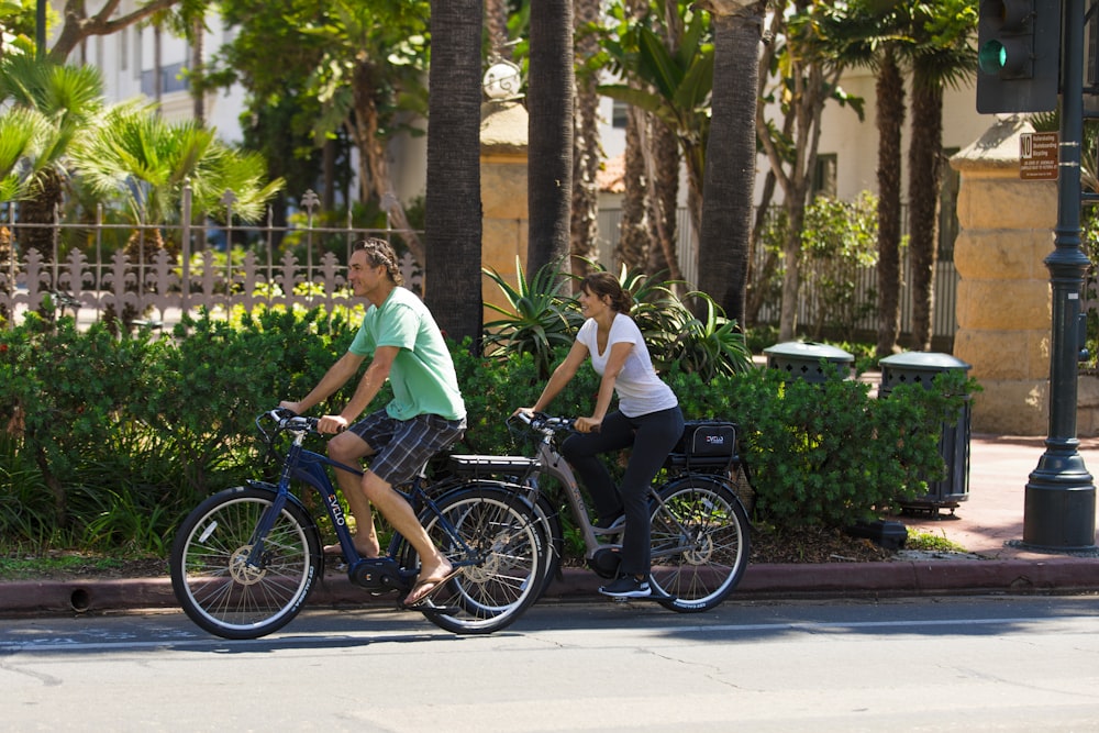 a couple of women riding bikes down a street