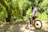 A smiling teen mountain biker wearing a helmet and team jersey, standing beside a rugged trail bike.