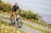 A happy customer riding a bike along a scenic road.