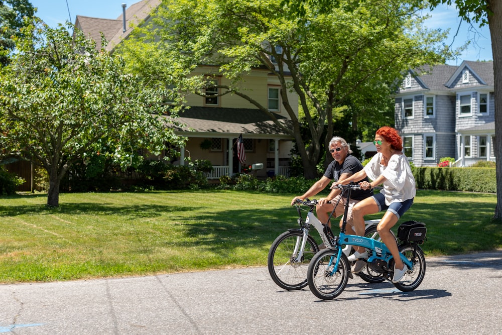 a man and a woman riding bikes down a street