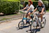 Couple riding electric bikes along a verdant trail with coastal views in Chiloé.