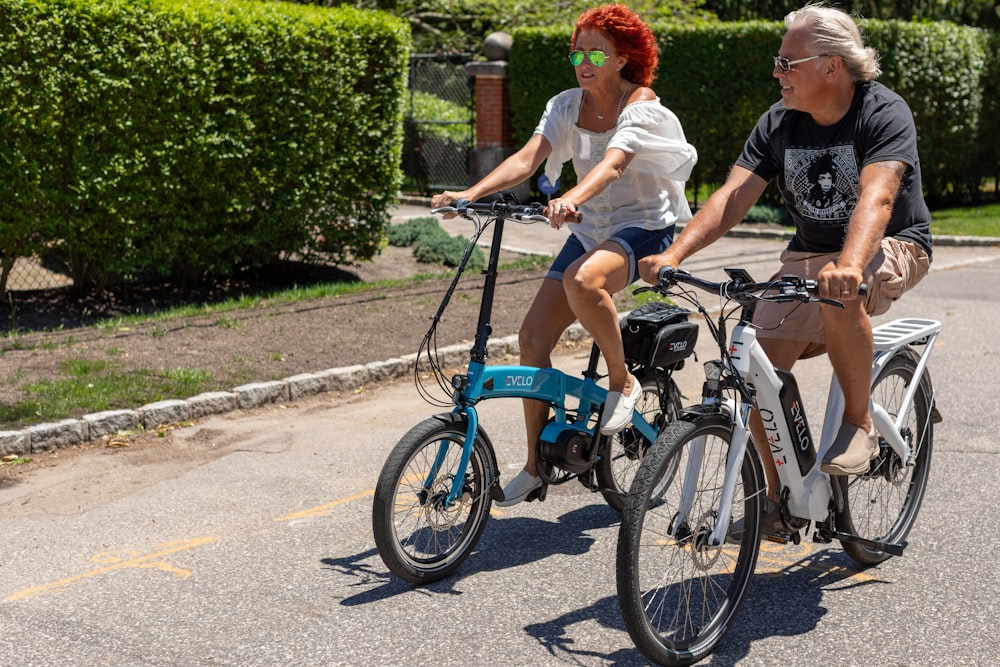 a man and a woman riding bikes down a street