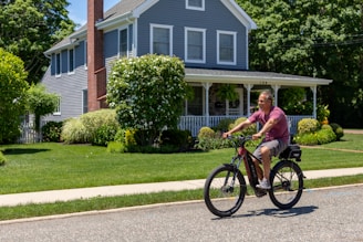 A rider enjoying a leisurely cruise on a Stateride e-bike through a leafy suburban street.