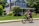 Smiling woman riding her new e-bike on a sunny day in a suburban neighborhood.