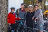 Smiling tourists wearing helmets ready to start their quadricycle adventure on a sunny day.