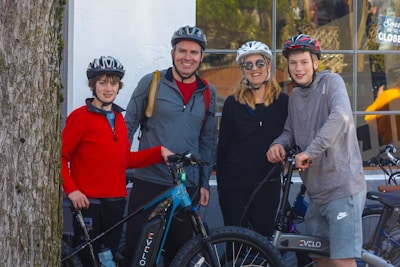 Group of friends with bicycles laughing and chatting outside the Trulli Bike Shop storefront.