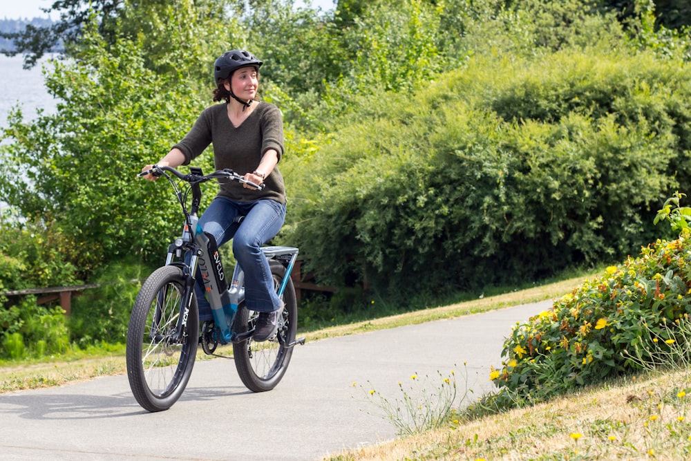 a woman riding a bike down a path