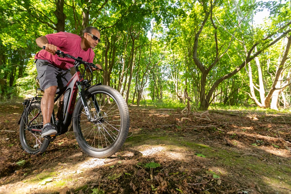 a man riding a mountain bike through a forest