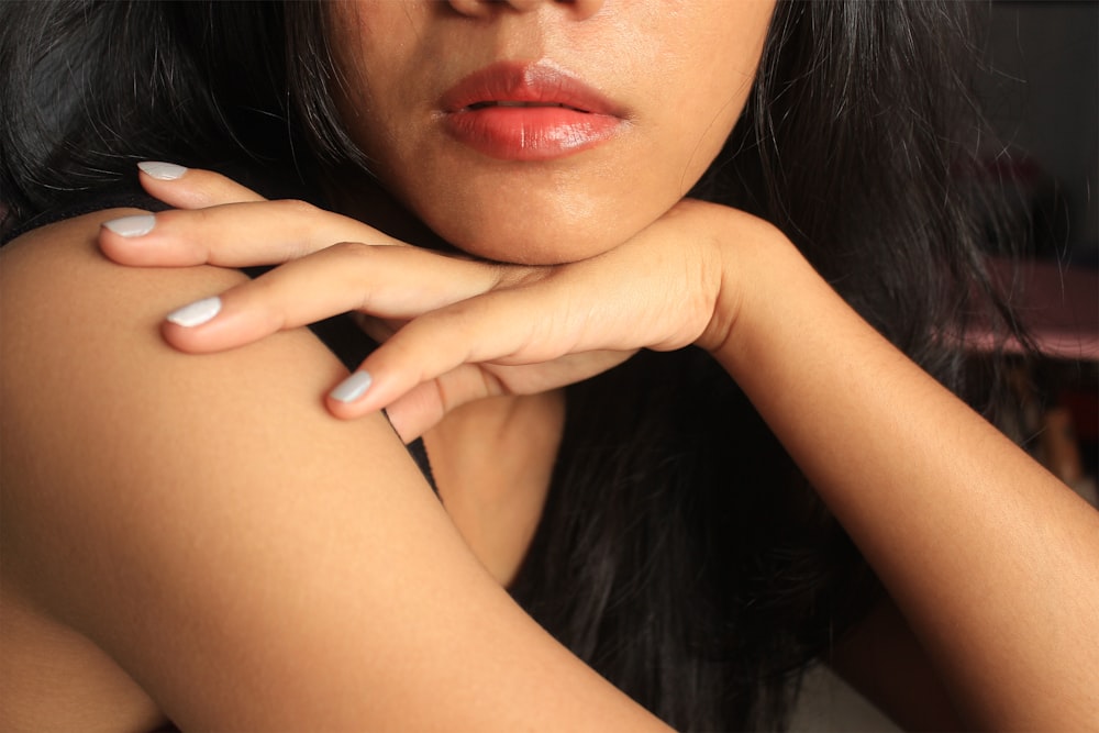 a close up of a woman with her hand on her shoulder