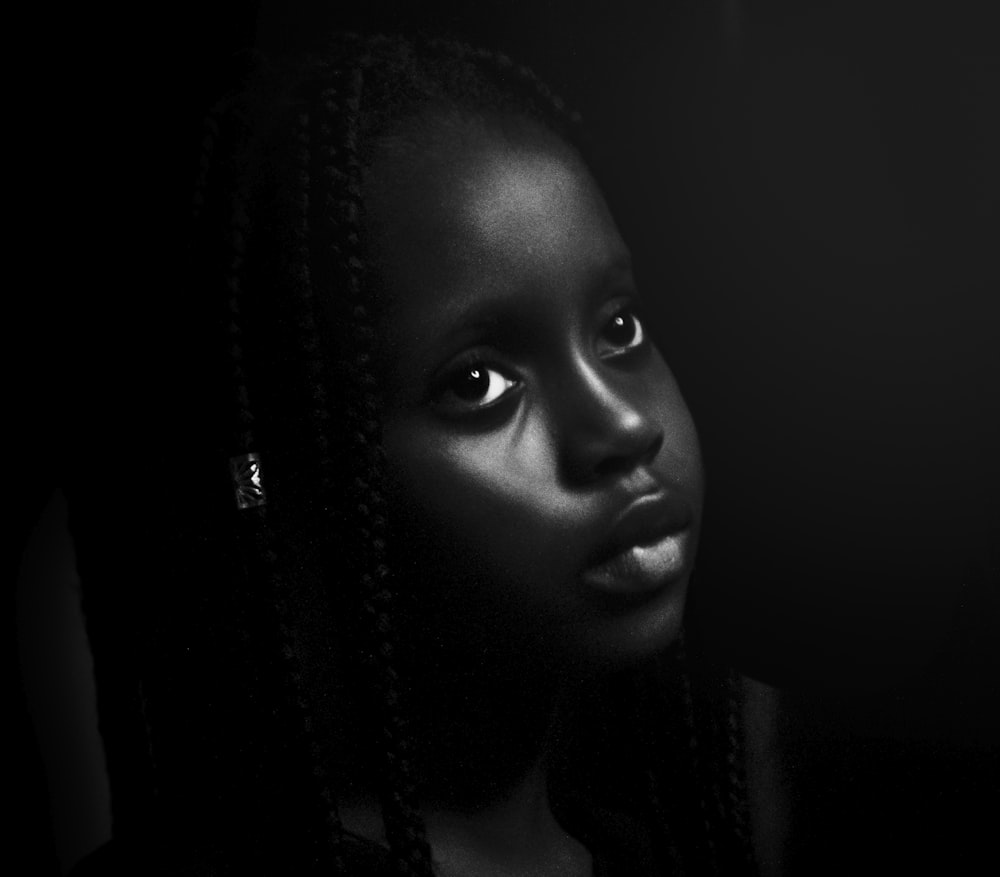 a black and white photo of a woman with braids