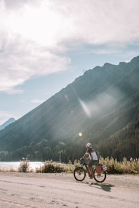 A cyclist riding a high-end bicycle on a scenic mountain road.