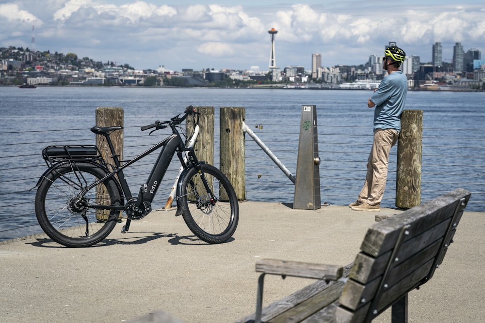a man standing next to a bike on a pier