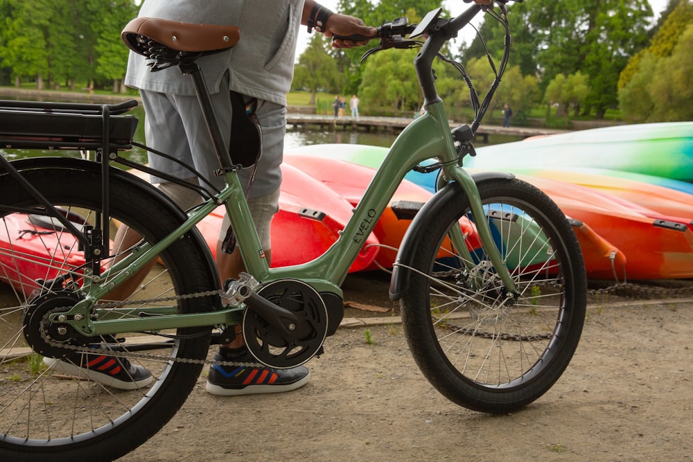 a man standing next to a green bike