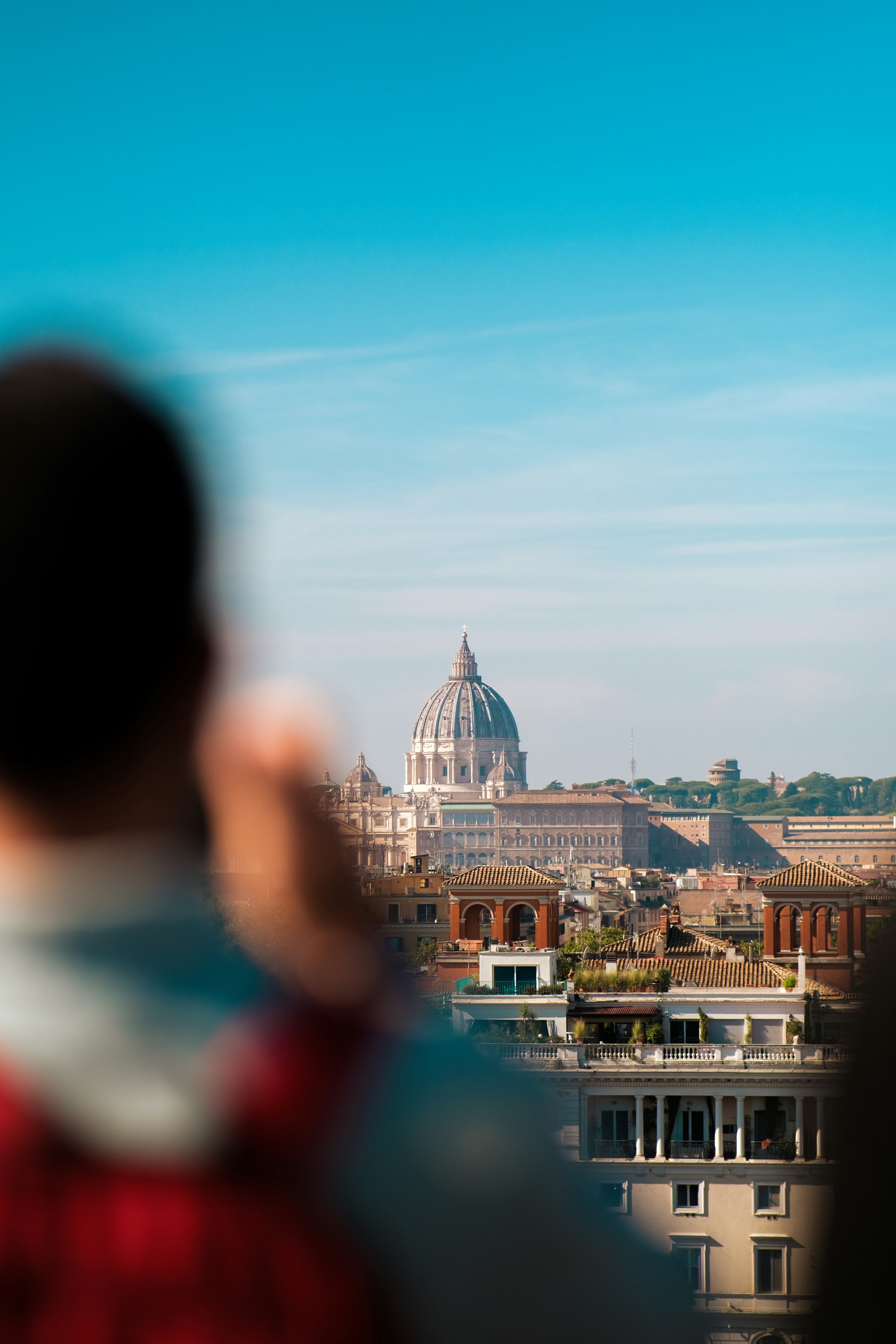 a man talking on a cell phone while standing in front of a city
