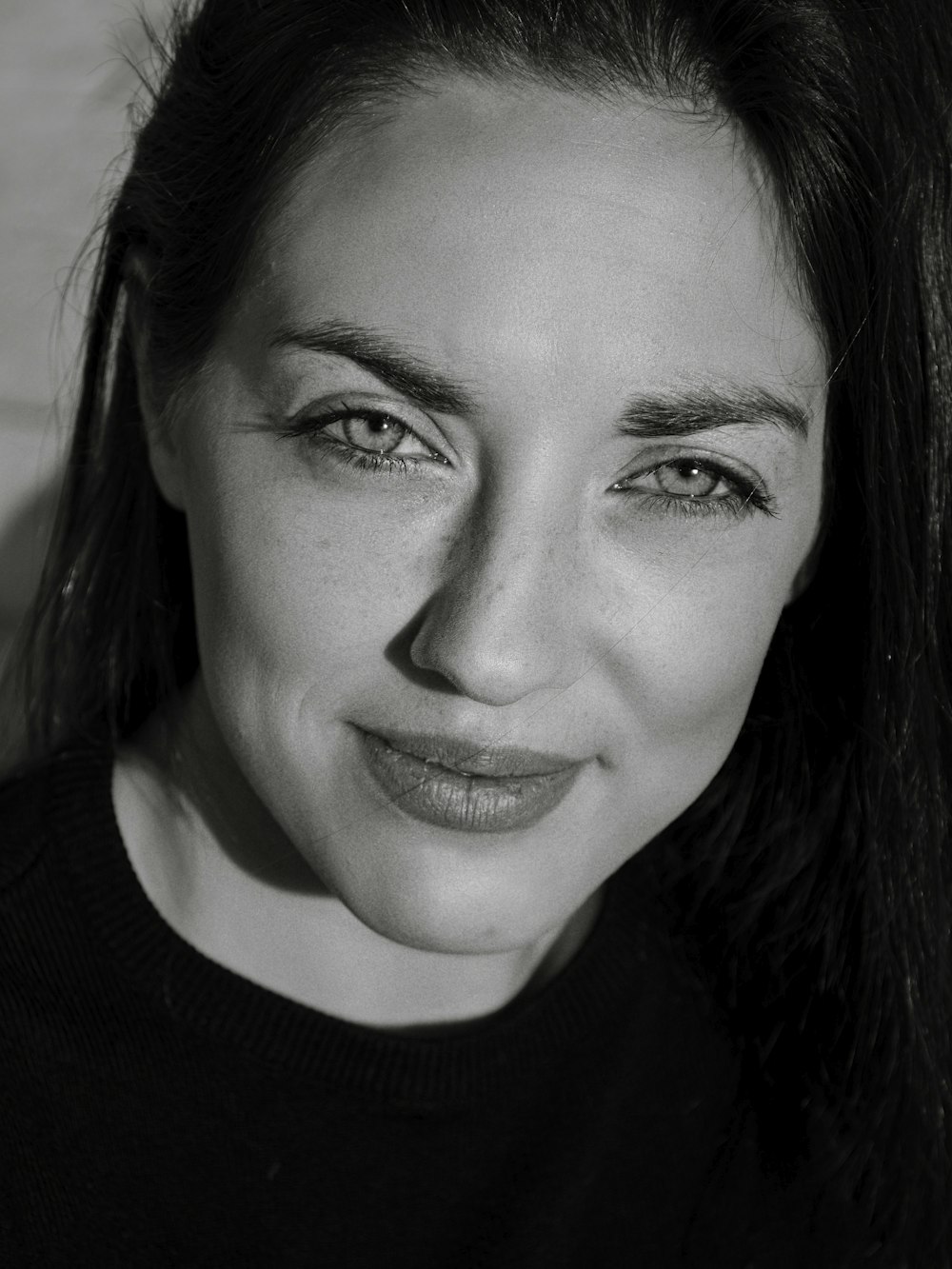 a black and white photo of a woman smiling