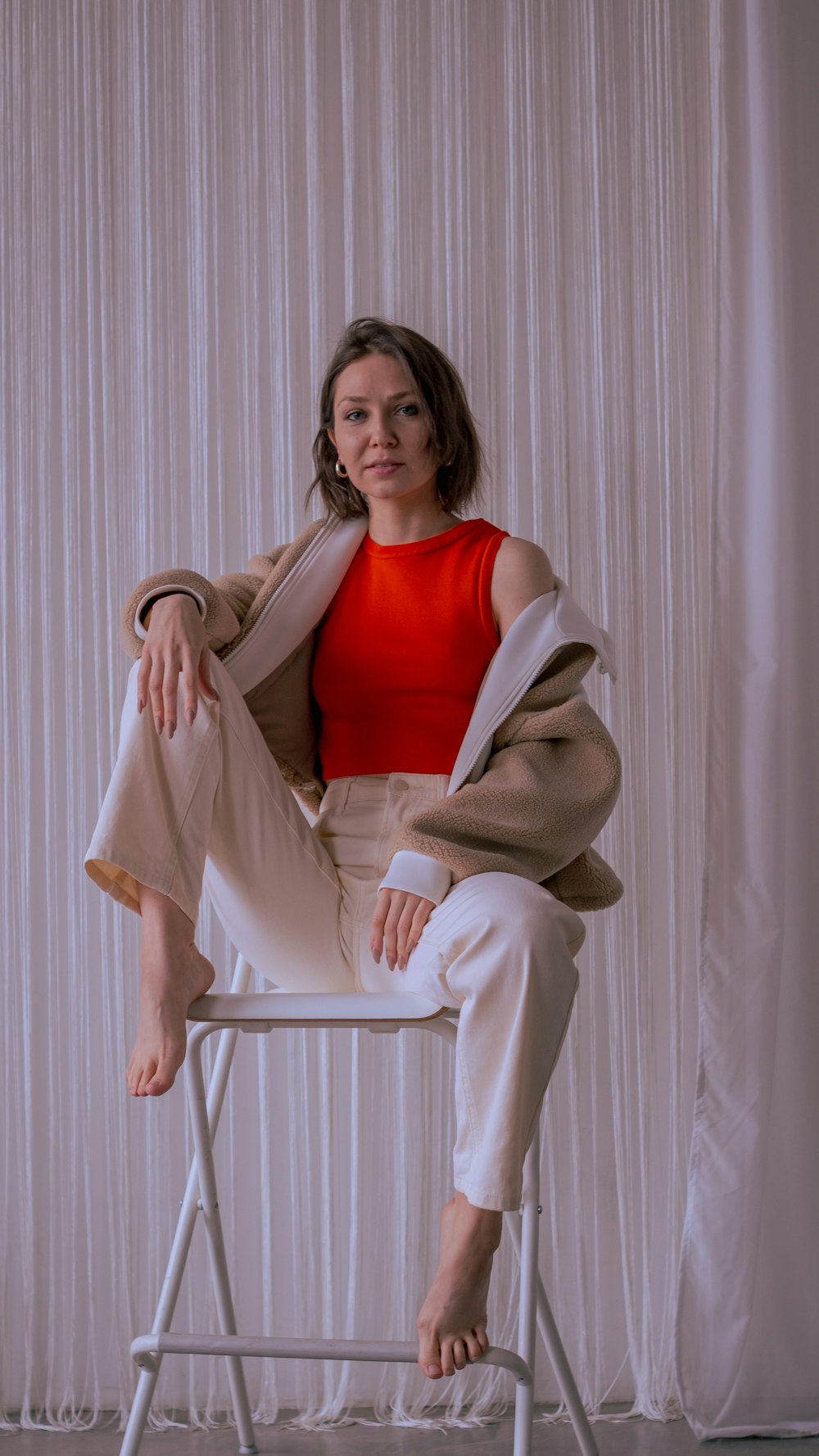 a woman sitting on top of a white chair