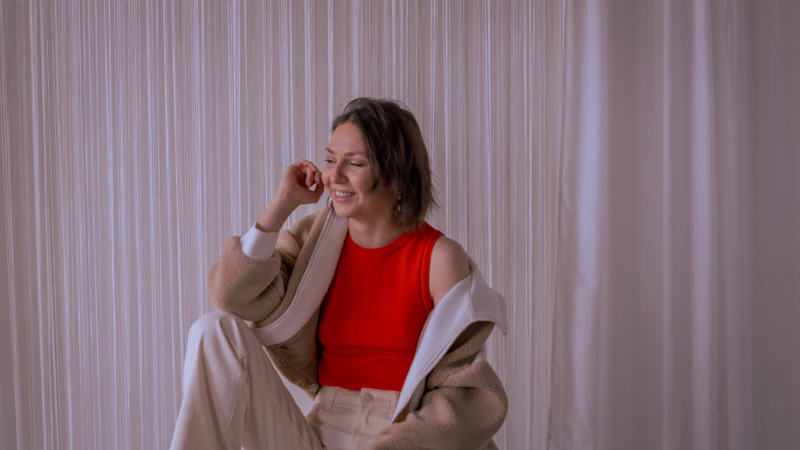a woman in a red top is sitting on a chair