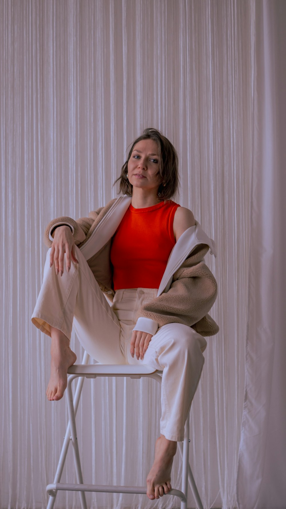 a woman sitting on top of a white chair