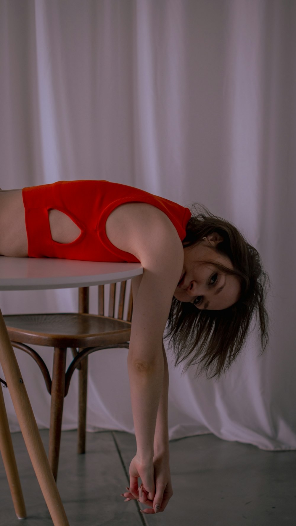 a woman in a red dress leaning over a table