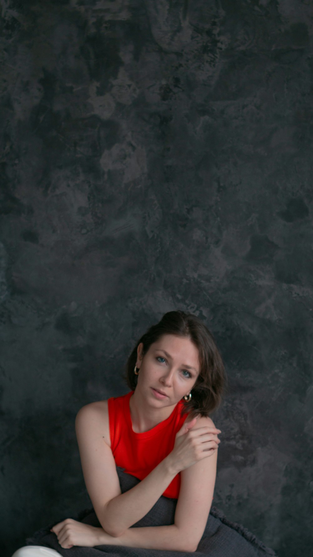 a woman in a red top sitting on a chair