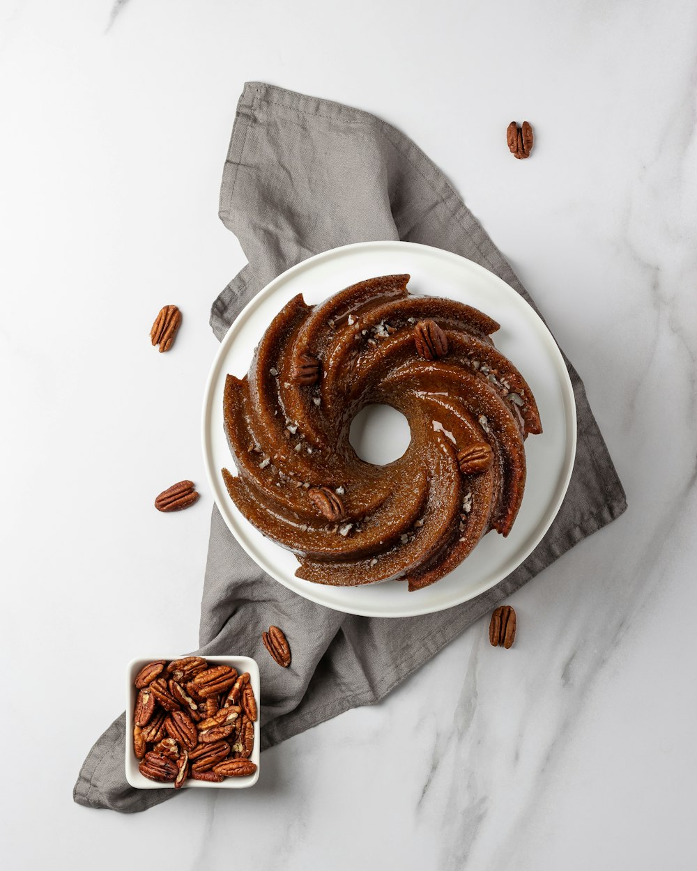 a white plate topped with sliced pecans next to a bowl of pecans