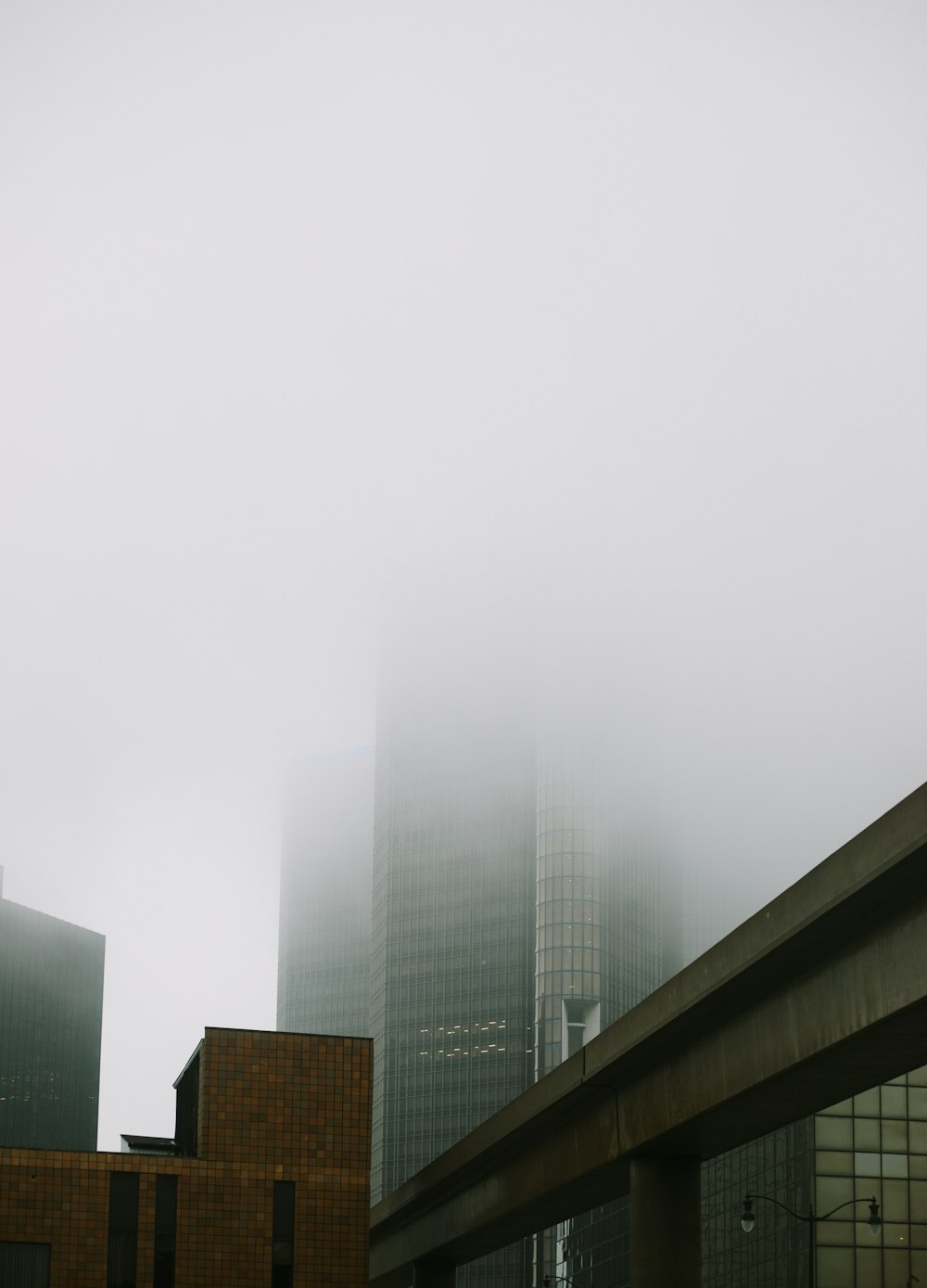 a very tall building in the middle of a foggy city