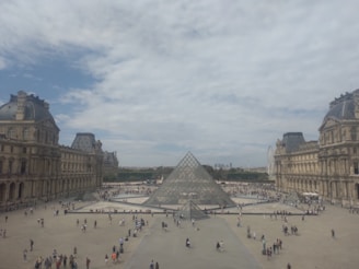 A candid photo of Ben warmly guiding a small group through the sunlit courtyard of the Louvre.