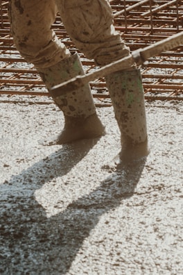 the legs of a person in muddy boots