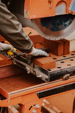 a person using a circular saw to cut a piece of wood