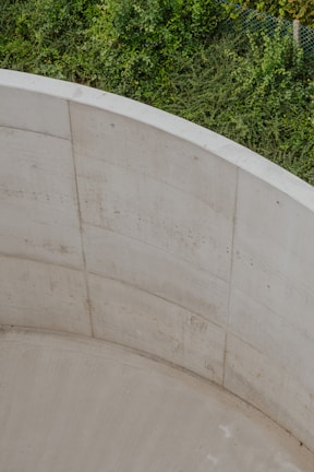 A sleek concrete fence framing a beautifully landscaped garden area.