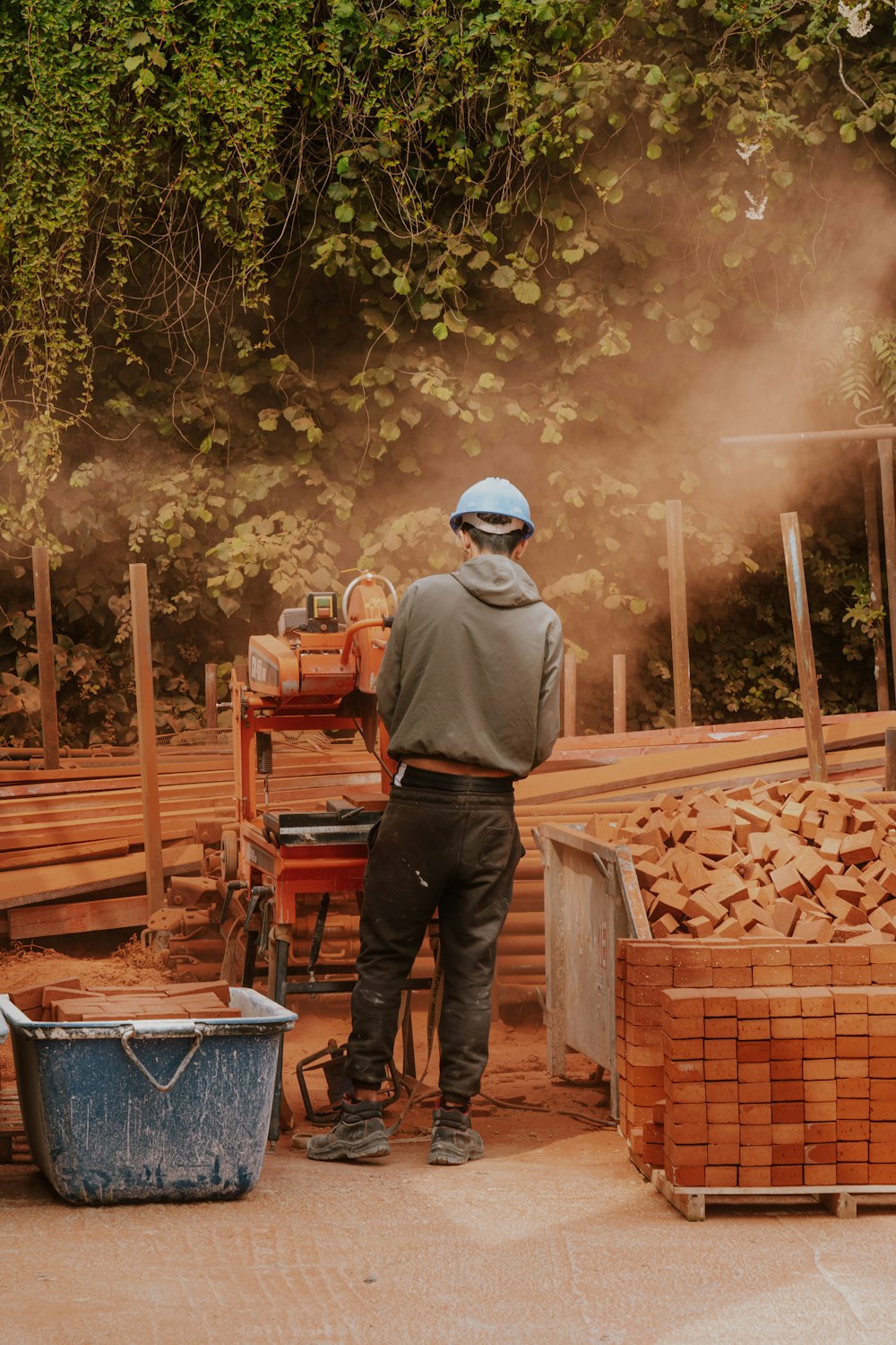 a man standing next to a pile of wood