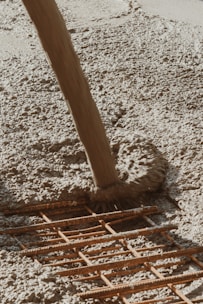 a wooden pole laying on top of a sandy beach