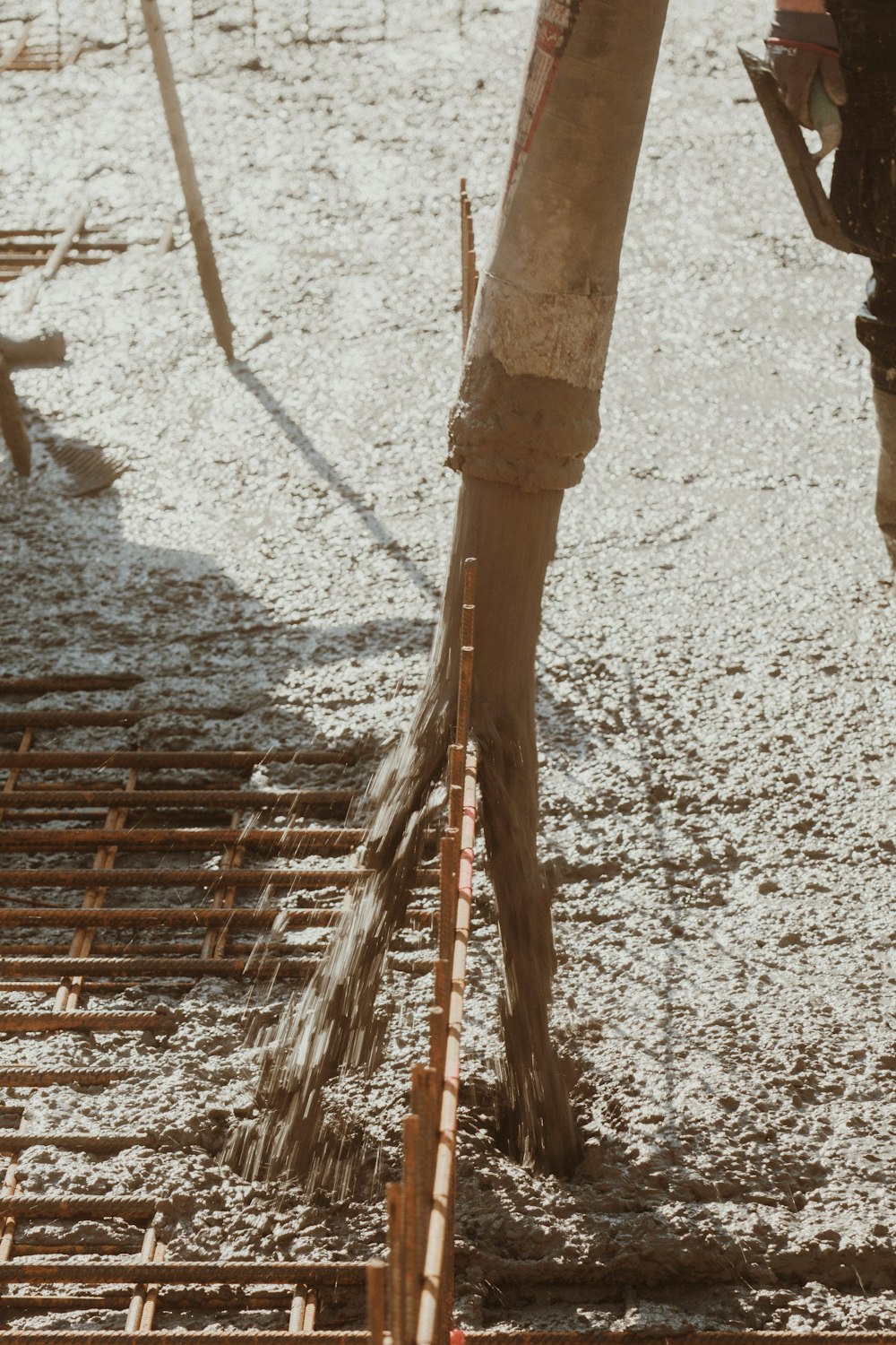 a worker pouring concrete onto a building under construction