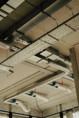 the ceiling of a building with pipes and lights