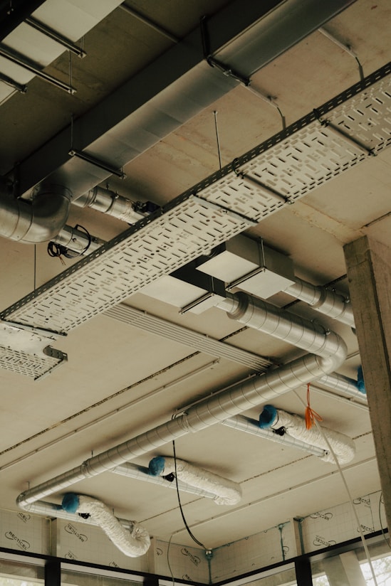 the ceiling of a building with pipes and lights