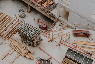 a large group of wooden beams sitting on top of a cement floor