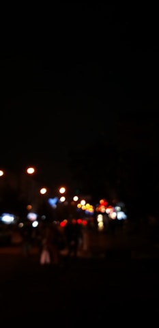 Blurred city lights gradually coming into sharp focus through a camera lens.